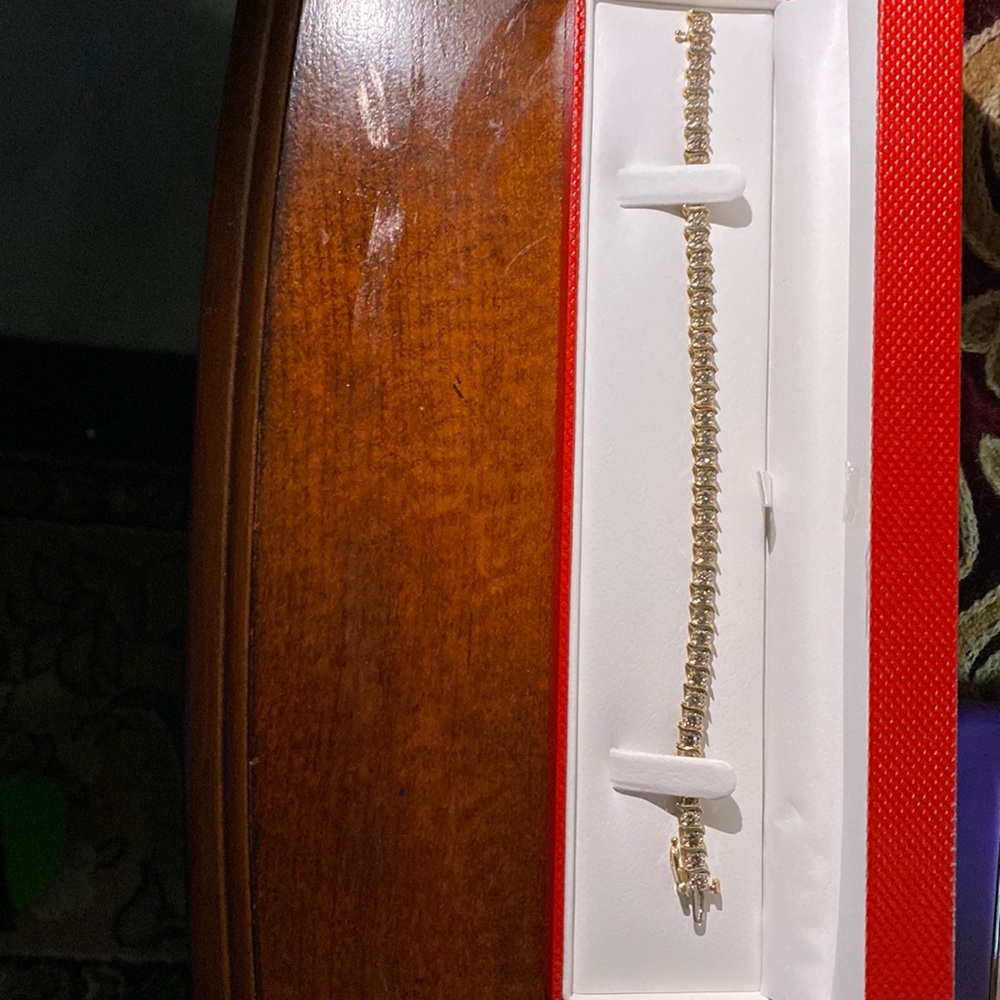 This is a newTennis Bracelet. It is an S link diamond Tennis bracelet with gold